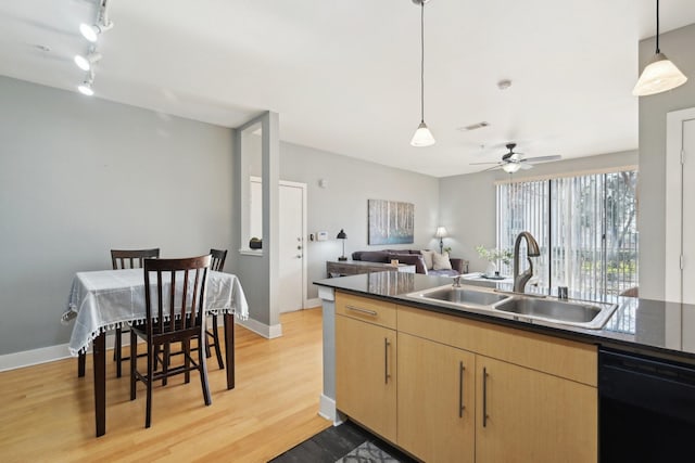 kitchen featuring sink, light hardwood / wood-style flooring, hanging light fixtures, black dishwasher, and light brown cabinetry