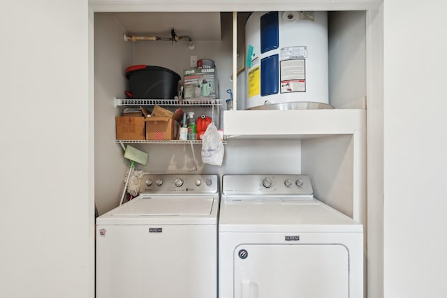 clothes washing area featuring electric water heater and washing machine and clothes dryer