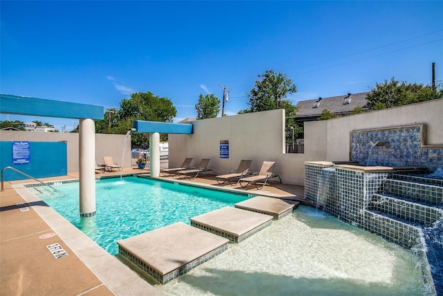 view of swimming pool with pool water feature and a patio area