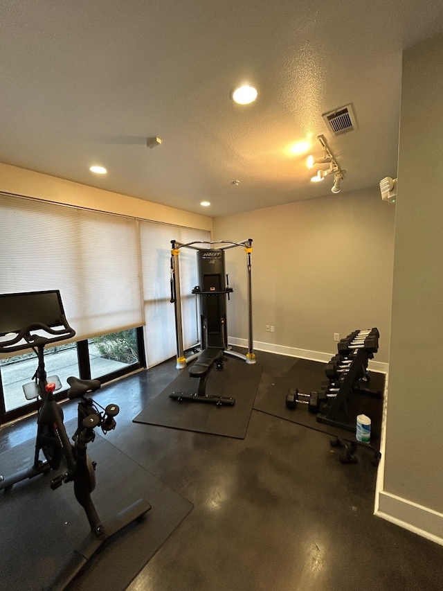 exercise room with a textured ceiling