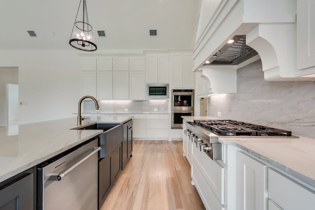 kitchen featuring white cabinetry, hanging light fixtures, stainless steel appliances, and premium range hood