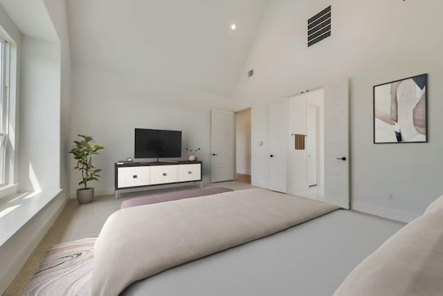 bedroom with high vaulted ceiling and multiple windows