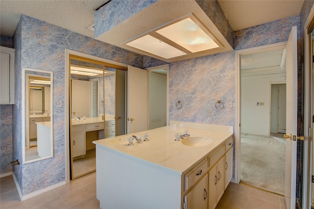 bathroom featuring tile patterned floors, a textured ceiling, and vanity