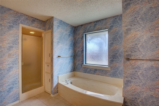 bathroom with tile patterned flooring, independent shower and bath, and a textured ceiling