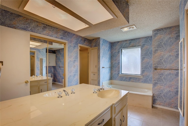 bathroom with vanity, separate shower and tub, tile patterned flooring, and a textured ceiling