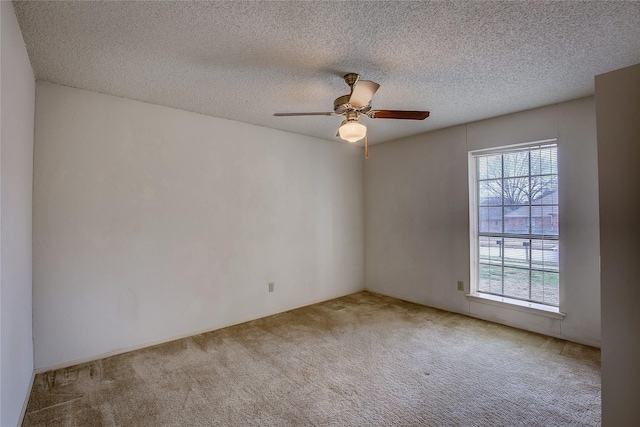 carpeted empty room with ceiling fan and a textured ceiling