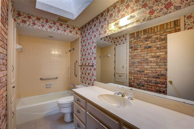 full bathroom with tiled shower / bath, a skylight, toilet, tile patterned floors, and a textured ceiling