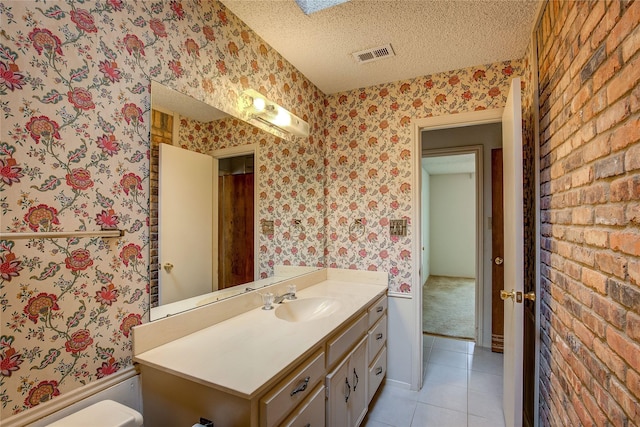 bathroom featuring vanity, toilet, tile patterned flooring, and a textured ceiling