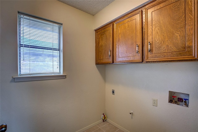 laundry area featuring cabinets, washer hookup, light tile patterned floors, hookup for an electric dryer, and a textured ceiling