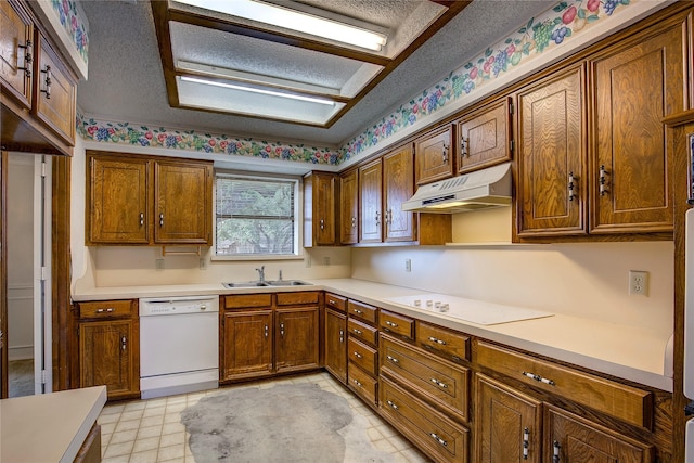 kitchen with sink, white appliances, and a textured ceiling