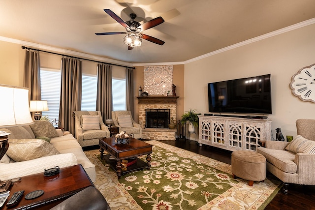 living room with hardwood / wood-style flooring, ornamental molding, ceiling fan, and a fireplace