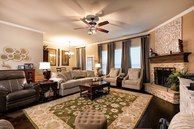 living room with a fireplace, ceiling fan with notable chandelier, dark wood-type flooring, and ornamental molding