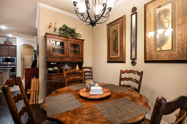 dining area featuring crown molding, dark hardwood / wood-style floors, and a chandelier