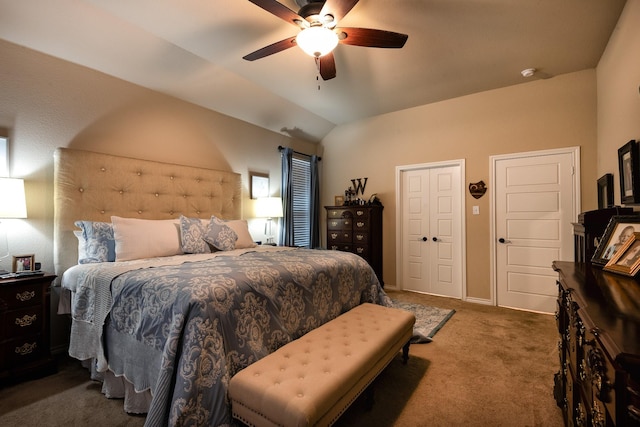 bedroom featuring dark carpet, vaulted ceiling, and ceiling fan