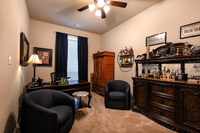 carpeted home office featuring ceiling fan