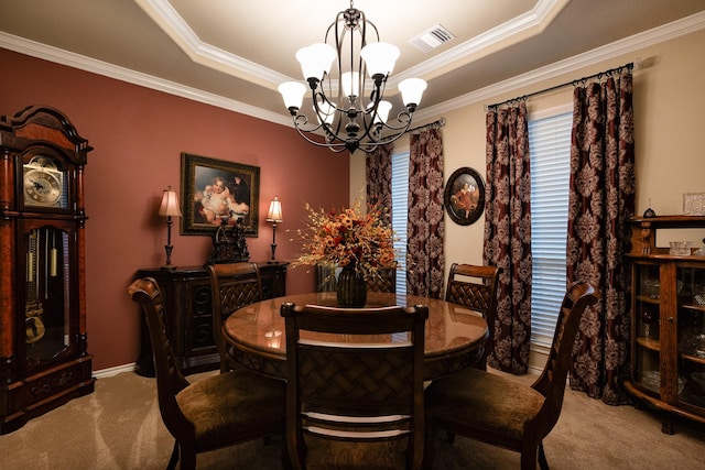 dining area with carpet, a tray ceiling, visible vents, ornamental molding, and a chandelier