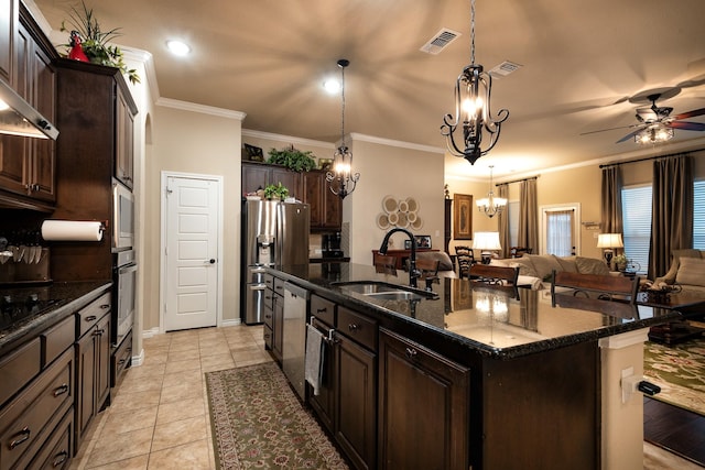 kitchen featuring pendant lighting, sink, appliances with stainless steel finishes, dark brown cabinetry, and a center island with sink