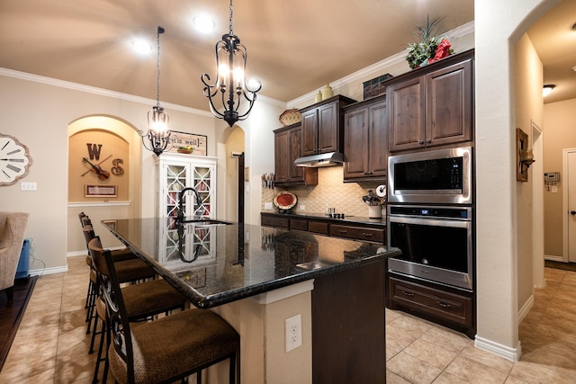 kitchen with dark brown cabinetry, sink, a center island with sink, and appliances with stainless steel finishes