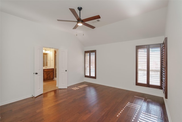 unfurnished bedroom featuring ceiling fan, dark hardwood / wood-style flooring, vaulted ceiling, and ensuite bath