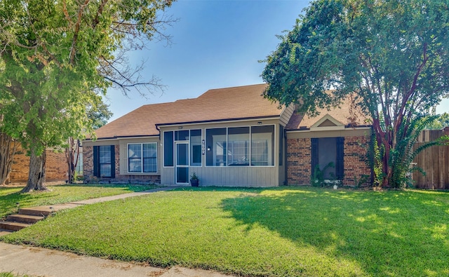 ranch-style home with a sunroom and a front yard