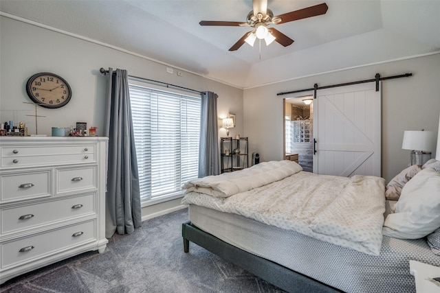 carpeted bedroom with ceiling fan, ensuite bath, a barn door, and a raised ceiling