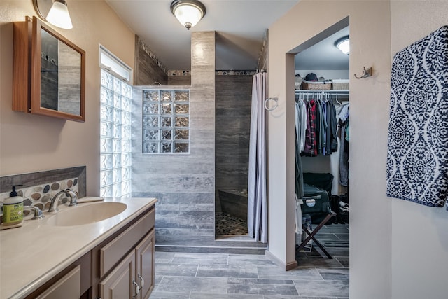 bathroom featuring a tile shower and vanity