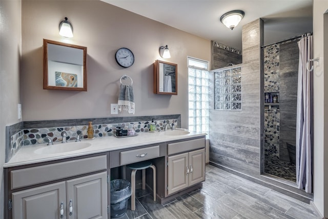 7502 Atlantic Dr, Rowlett, TX 75088 - full bath with a tile shower, double vanity, a fireplace, backsplash, and wood finished floors