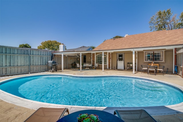 view of swimming pool with grilling area and a patio area