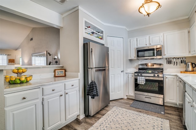 kitchen featuring white cabinetry, appliances with stainless steel finishes, vaulted ceiling, and hardwood / wood-style floors