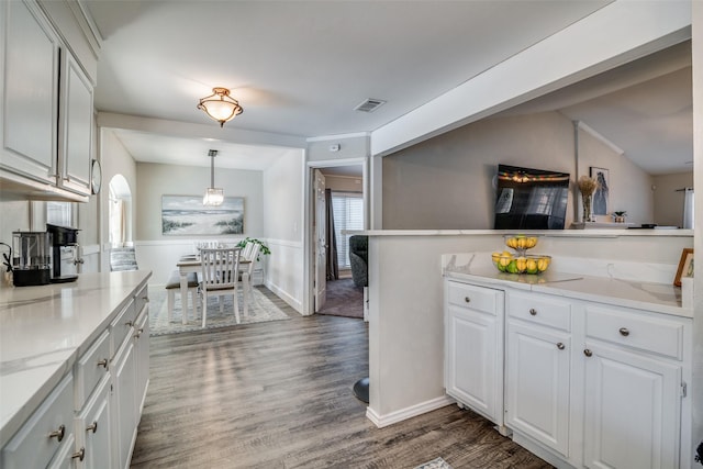 kitchen with hanging light fixtures, white cabinetry, dark hardwood / wood-style floors, and light stone counters