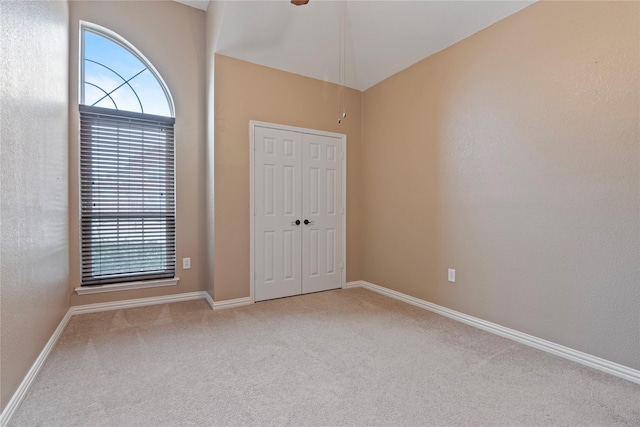 interior space featuring light carpet, multiple windows, and a closet