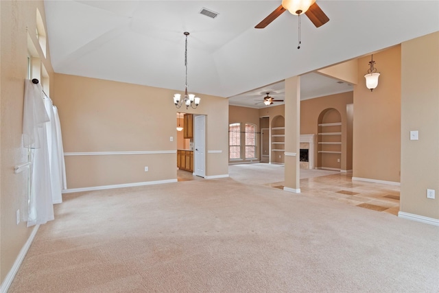 empty room featuring light carpet, built in shelves, and ceiling fan with notable chandelier