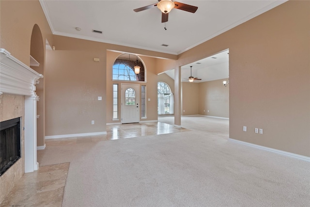 carpeted entrance foyer featuring crown molding, ceiling fan, and a towering ceiling