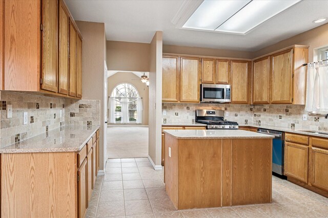 kitchen with tasteful backsplash, sink, light stone counters, and white appliances