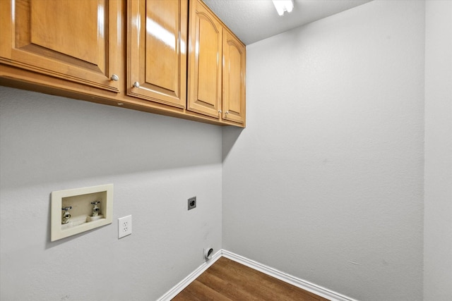 washroom featuring electric dryer hookup, hookup for a washing machine, wood-type flooring, and cabinets