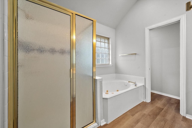 bathroom featuring plus walk in shower, vaulted ceiling, and hardwood / wood-style floors