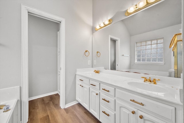 bathroom with lofted ceiling, vanity, a bathing tub, and hardwood / wood-style floors