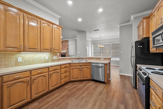 kitchen with sink, hanging light fixtures, ornamental molding, appliances with stainless steel finishes, and kitchen peninsula