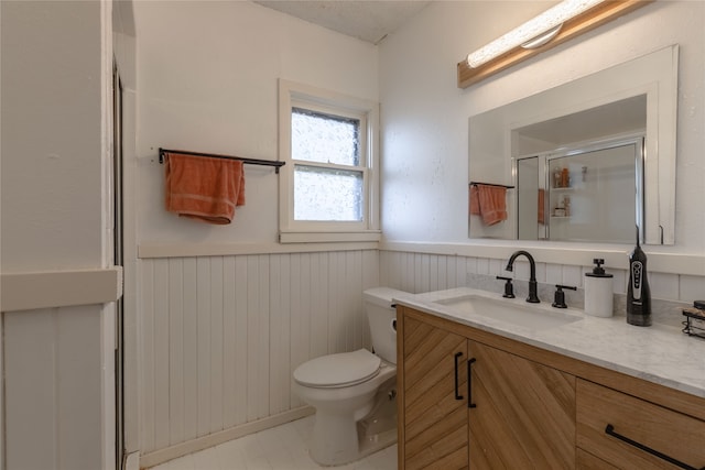 bathroom featuring vanity, toilet, and a shower with door