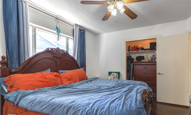 bedroom with ceiling fan, a textured ceiling, and dark hardwood / wood-style flooring