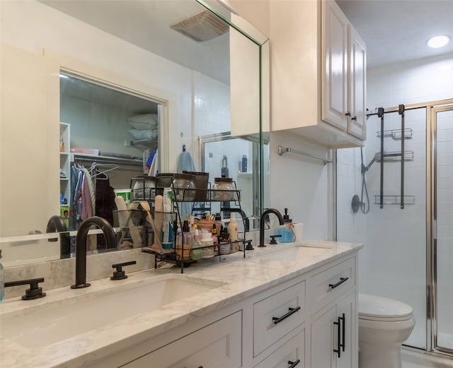 bathroom featuring vanity, toilet, and a shower with shower door