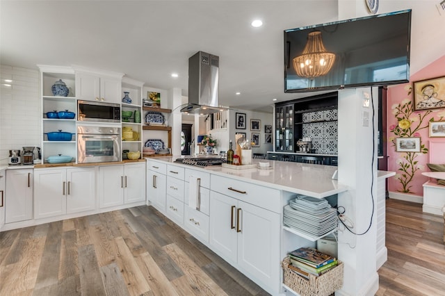 kitchen with stainless steel appliances, island exhaust hood, white cabinets, and light wood-type flooring