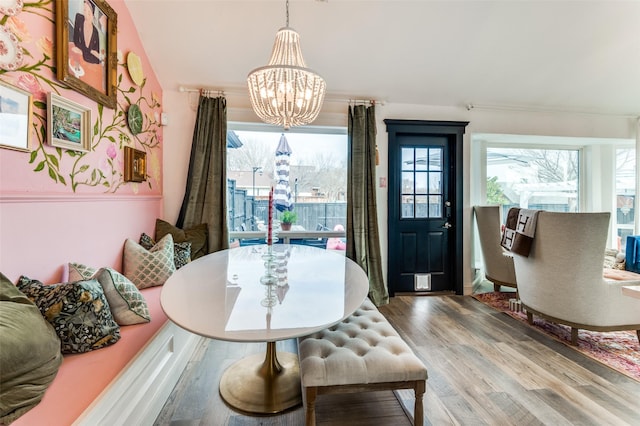 dining area with wood-type flooring and a notable chandelier