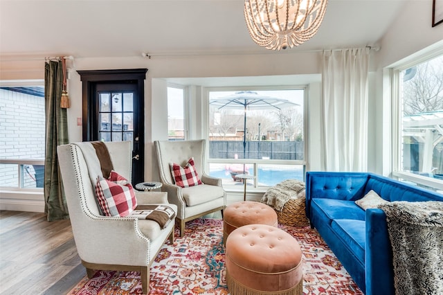 sitting room with plenty of natural light, hardwood / wood-style floors, and a notable chandelier