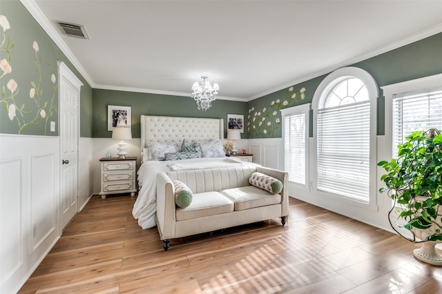 bedroom with ornamental molding, hardwood / wood-style floors, and a notable chandelier