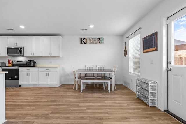 kitchen with white cabinetry, appliances with stainless steel finishes, and light wood-type flooring