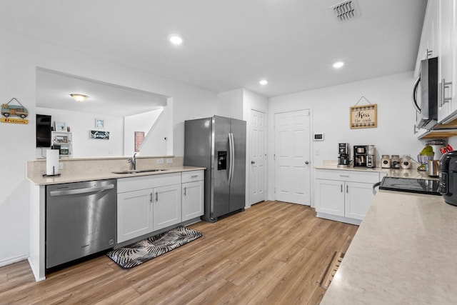 kitchen featuring sink, stainless steel appliances, light hardwood / wood-style floors, and white cabinets