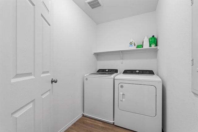 laundry room with washing machine and clothes dryer and dark hardwood / wood-style floors