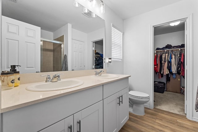 bathroom featuring an enclosed shower, hardwood / wood-style floors, vanity, and toilet