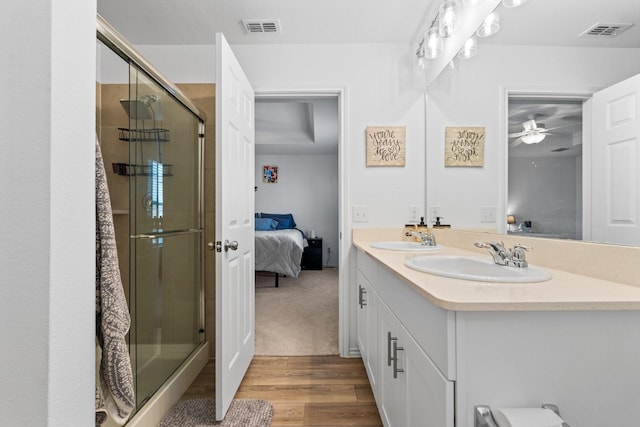 bathroom with vanity, hardwood / wood-style flooring, and a shower with door